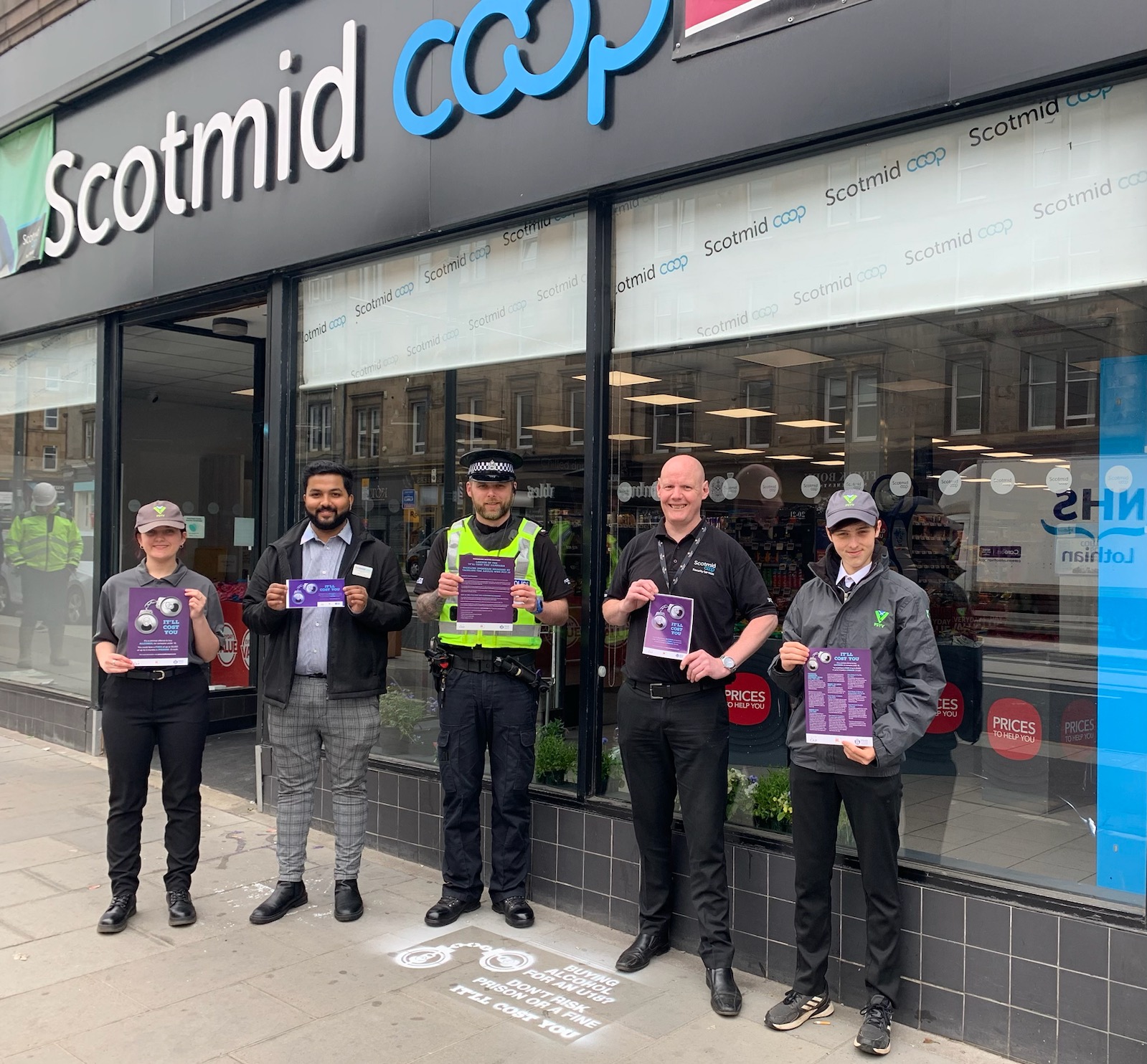 Police Scotland Youth Volunteers with staff and Police officer displaying It will Cost you leaflet outside shop